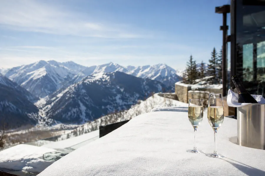 Terraza de lujo en Aspen con copas de champán y vistas a las Rockies