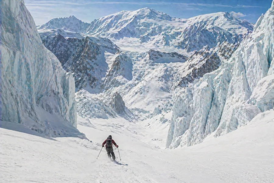 Esquiador descendiendo la Vallée Blanche entre seracs de hielo azul en Chamonix