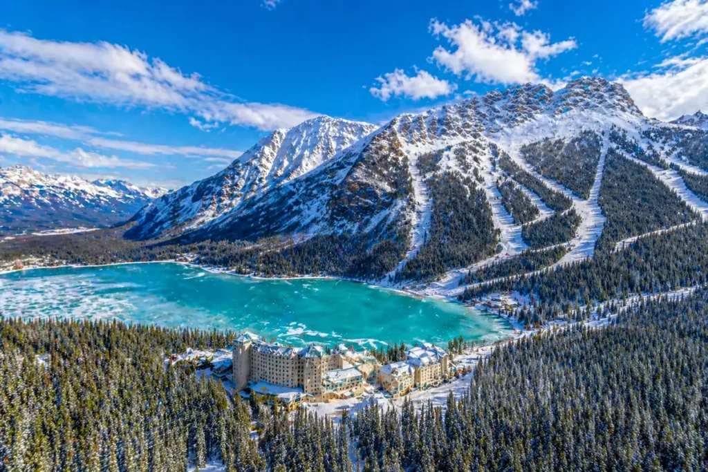 Vista aérea del lago Louise helado con pistas de esquí y el hotel Fairmont en invierno
