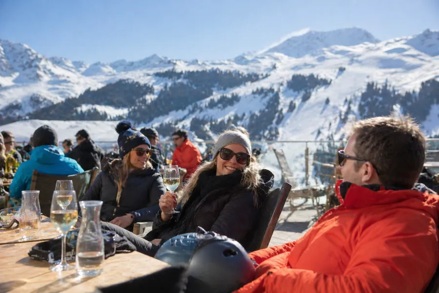 Terraza de après-ski en St. Anton con esquiadores disfrutando al sol