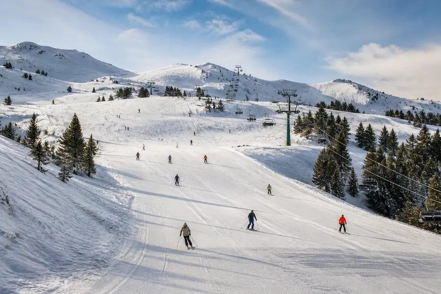 Esquiadores descendiendo por una pista amplia en Baqueira Beret con terreno suave