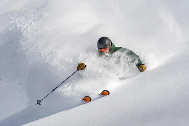 Esquiador descendiendo entre nieve profunda en Fernie, Canadá, rodeado de powder seco y una atmósfera auténtica de montaña.