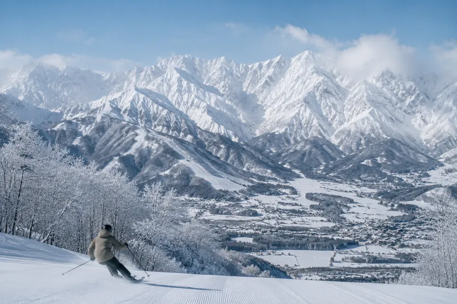 Esquiador en Hakuba Valley con montañas alpinas nevadas en Nagano Japón