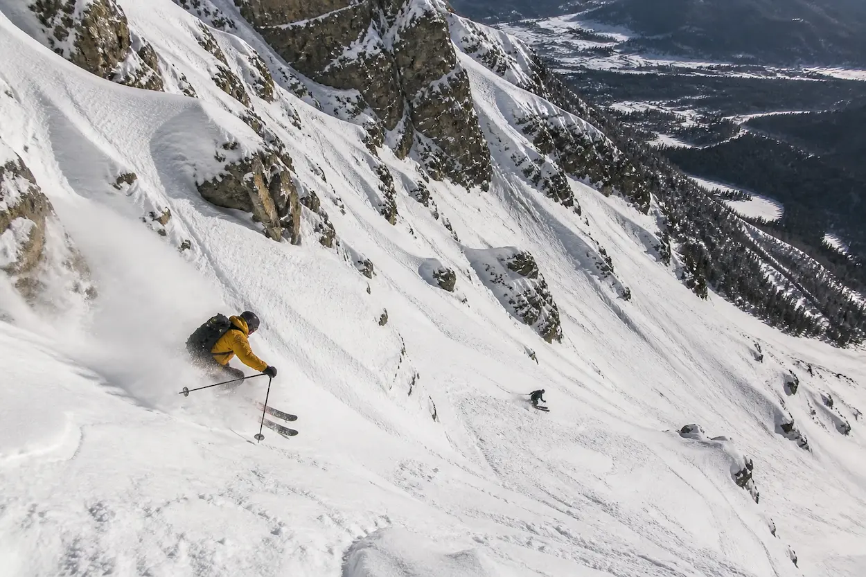 Esquiador entrando en un couloir estrecho en Jackson Hole con fuerte pendiente y terreno expuesto