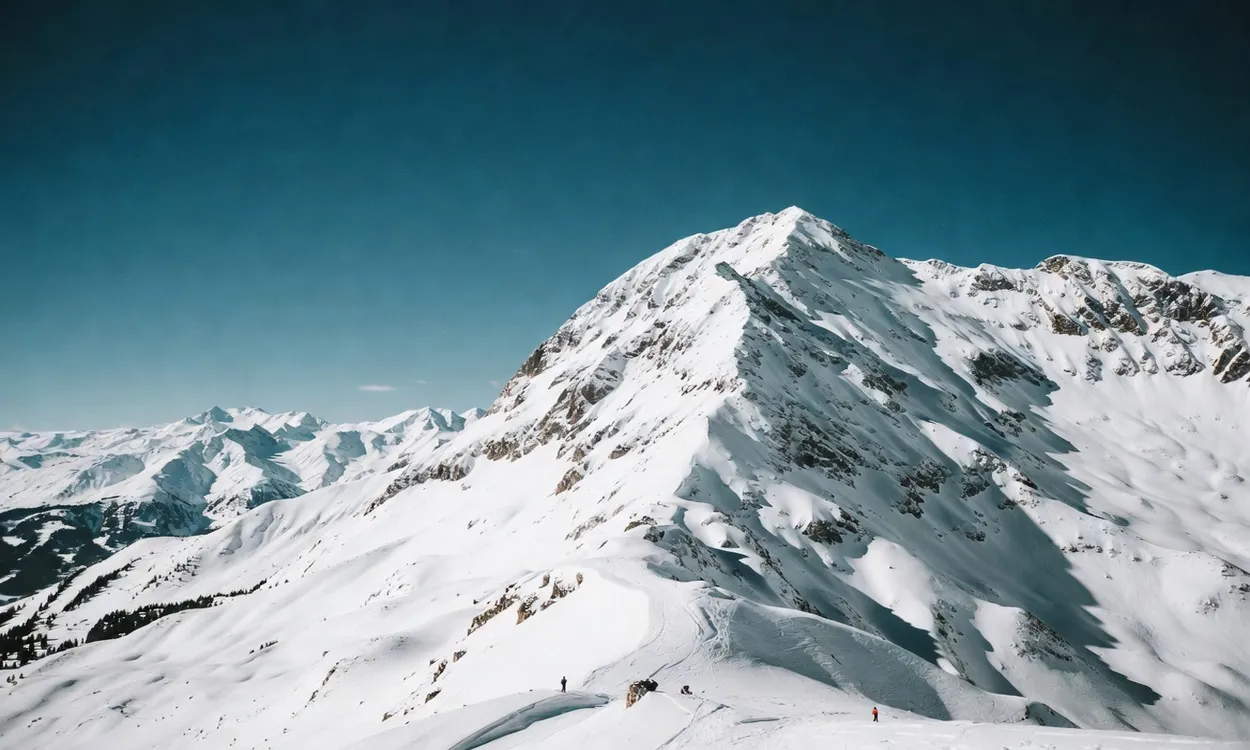 Vista dramática del Hahnenkamm con esquiadores a escala en los Alpes austriacos
