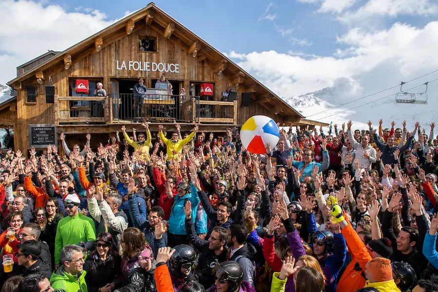 Multitud celebrando après-ski frente a La Folie Douce en los Alpes franceses