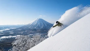 Esquiador descendiendo nieve polvo en Niseko con el monte Yotei al fondo en Japón.
