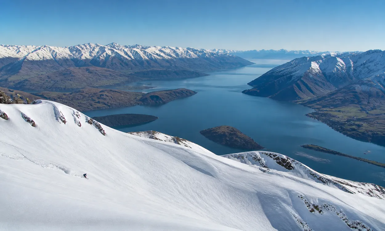 Pistas de freeride en Treble Cone con el lago Wanaka extendiéndose al fondo, Isla Sur de Nueva Zelanda