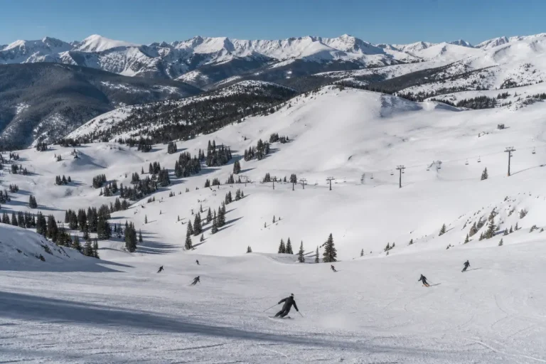 Esquiadores descendiendo en los back bowls de Vail con terreno amplio y suave en una estación de esquí en Colorado