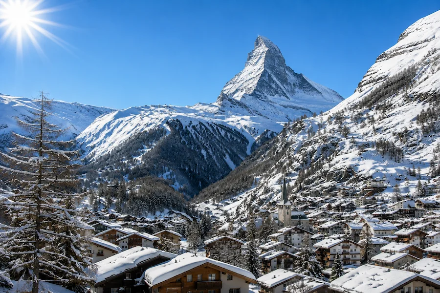 Vista diurna de Zermatt nevado con el Matterhorn despejado al fondo bajo cielo azul